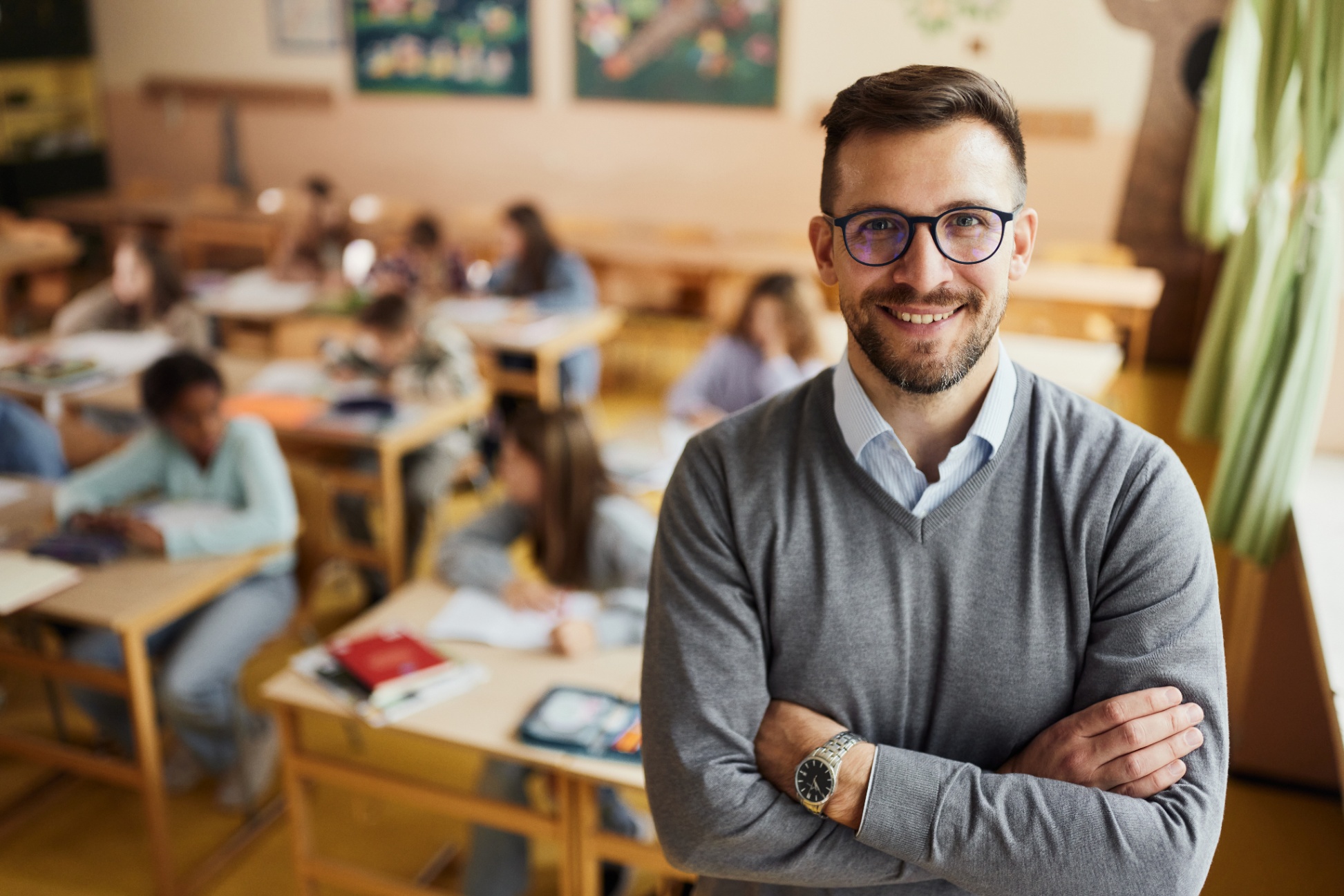 A teacher standing in front of a classroom with students working at desks